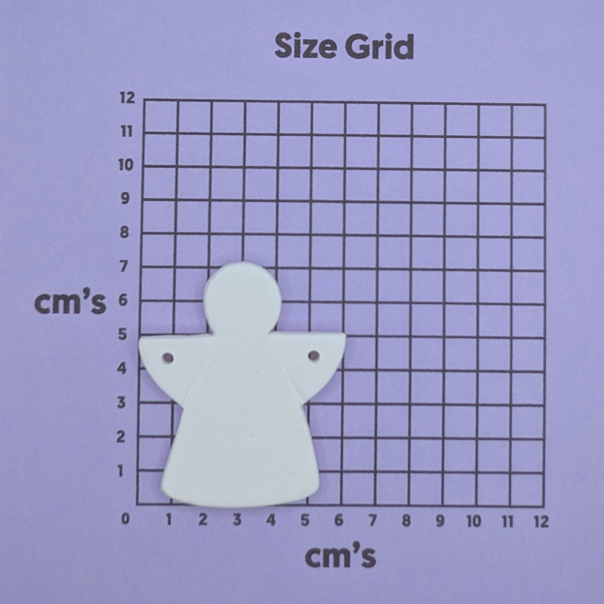 White angel decorationon a size grid with measurements in centimeters 