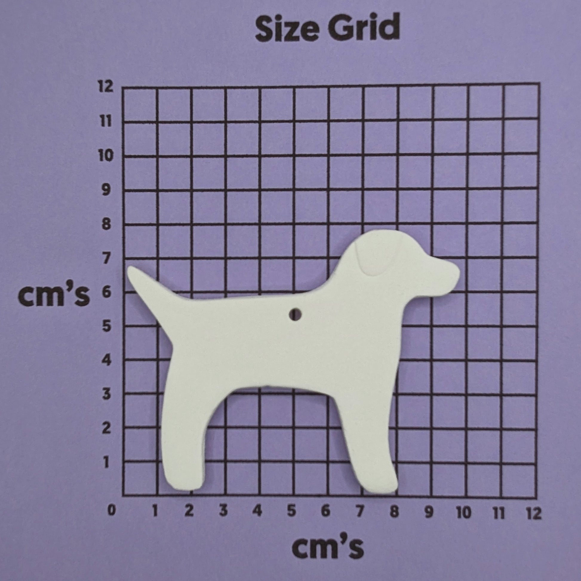 White dog-shaped decoration on a size grid with measurements in centimeters on a purple background