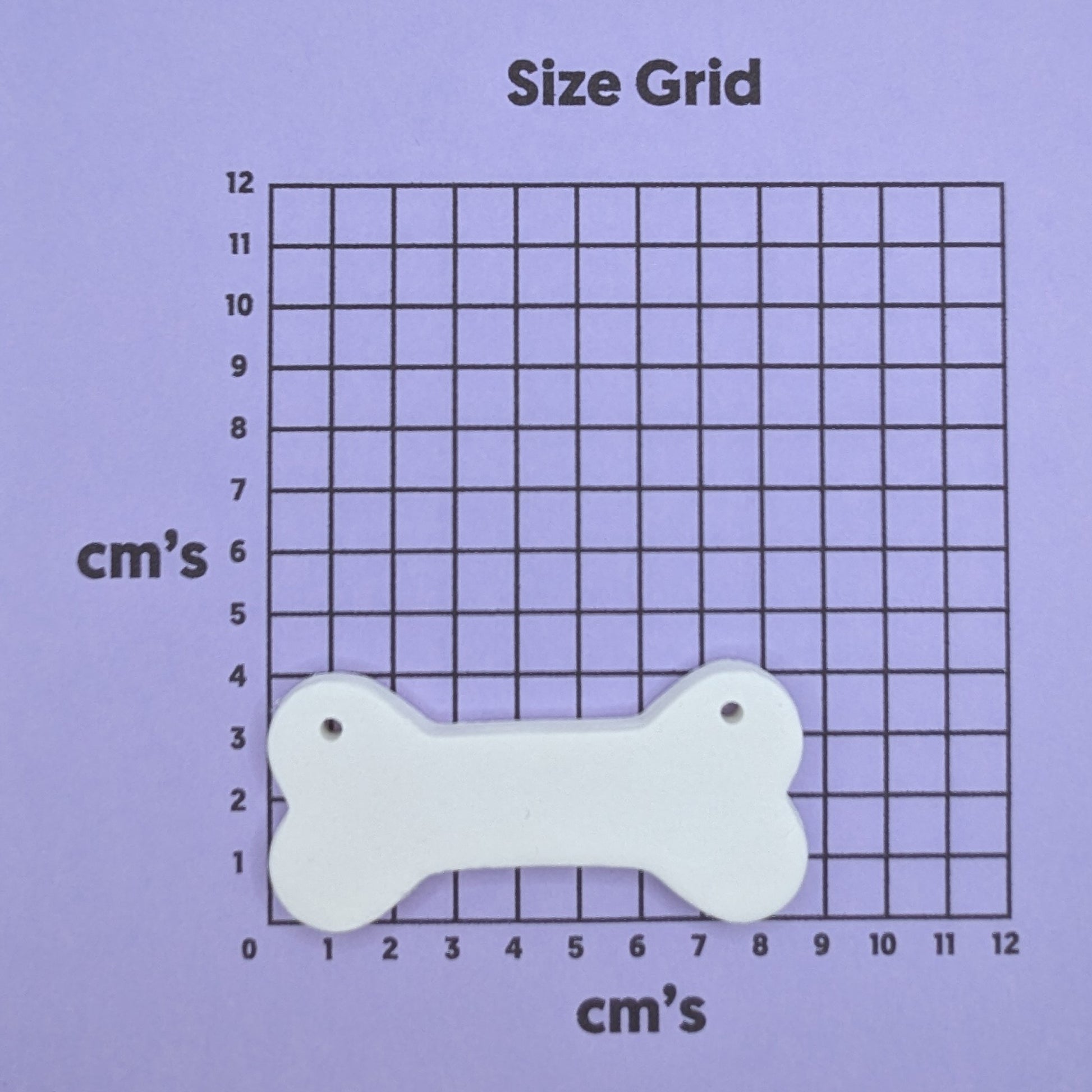 clay bone decoration on a size grid with measurements in centimeters 