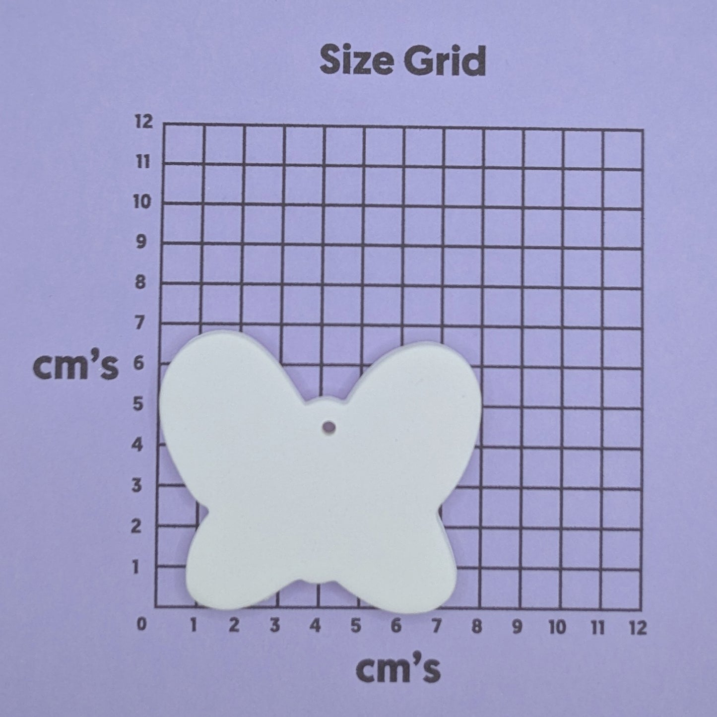 clay small butterfly decoration on a size grid with measurements in centimeters 