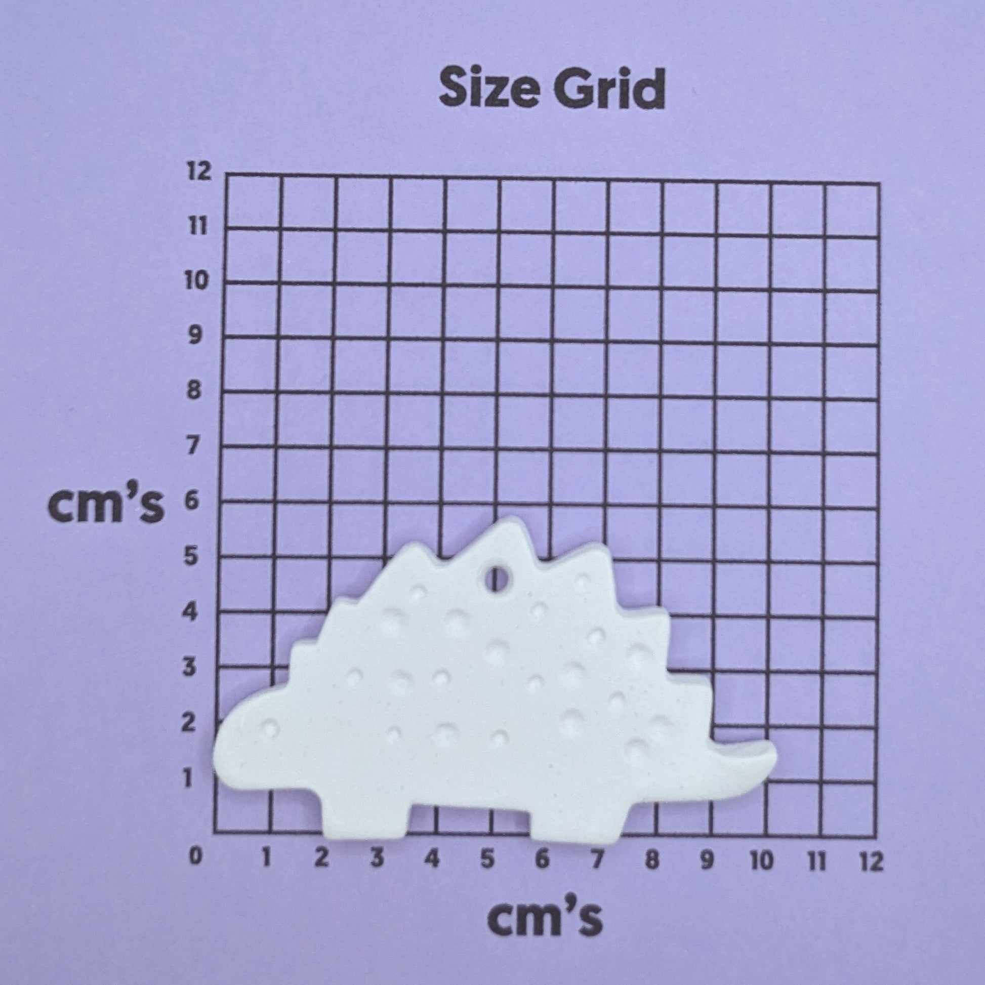clay dinosaur decoration on a size grid with measurements in centimeters 