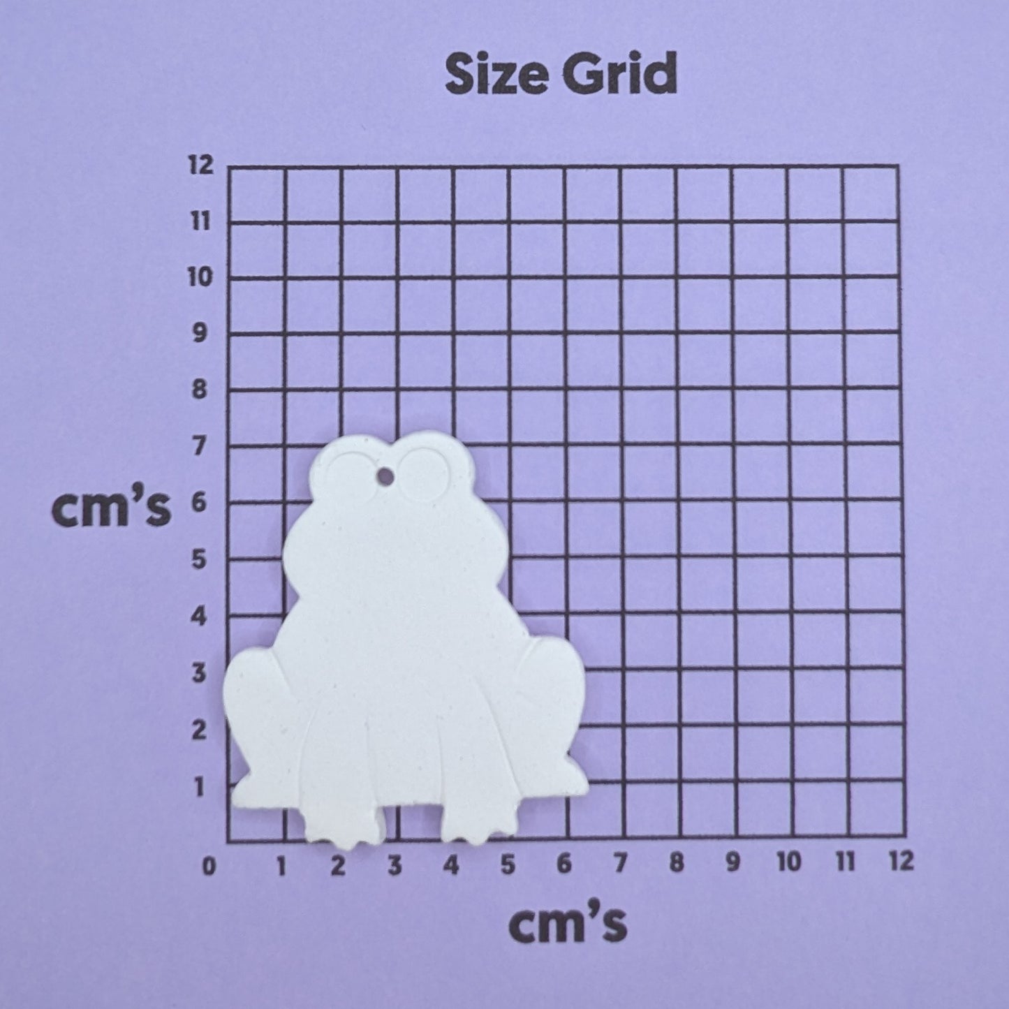 clay frog decoration on a size grid with measurements in centimeters 
