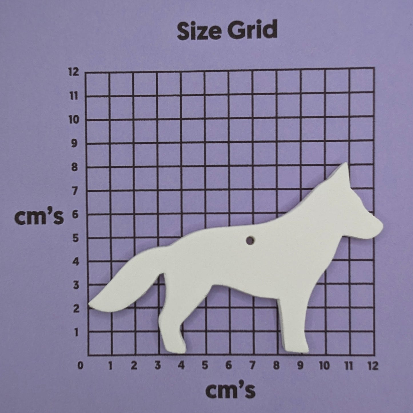 German shepherd dog shaped clay decoration shown on a cm size grid to show size