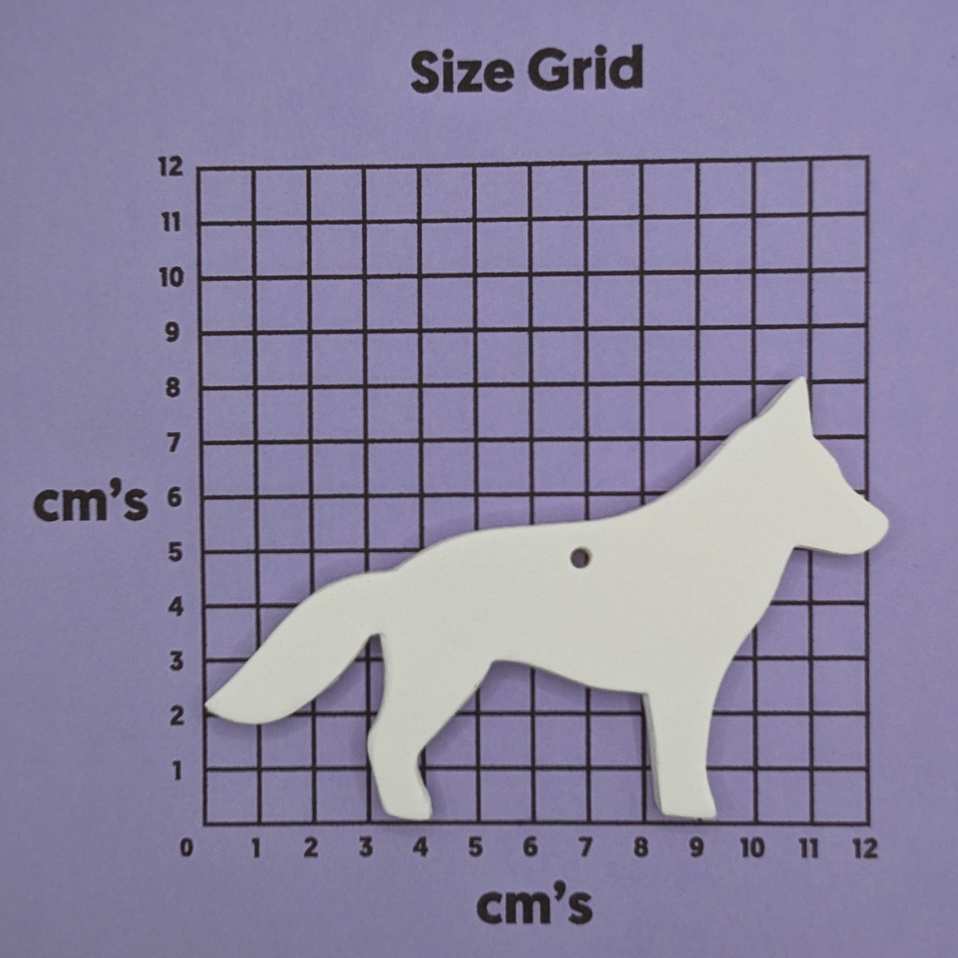 German shepherd dog shaped clay decoration shown on a cm size grid to show size