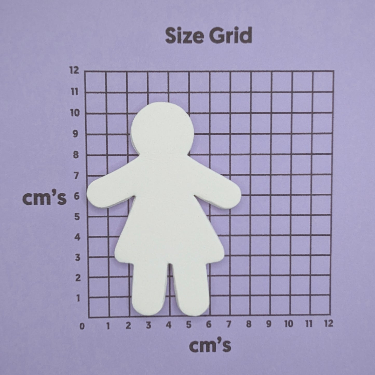 female shaped clay decoration on a size grid with centimeter measurements