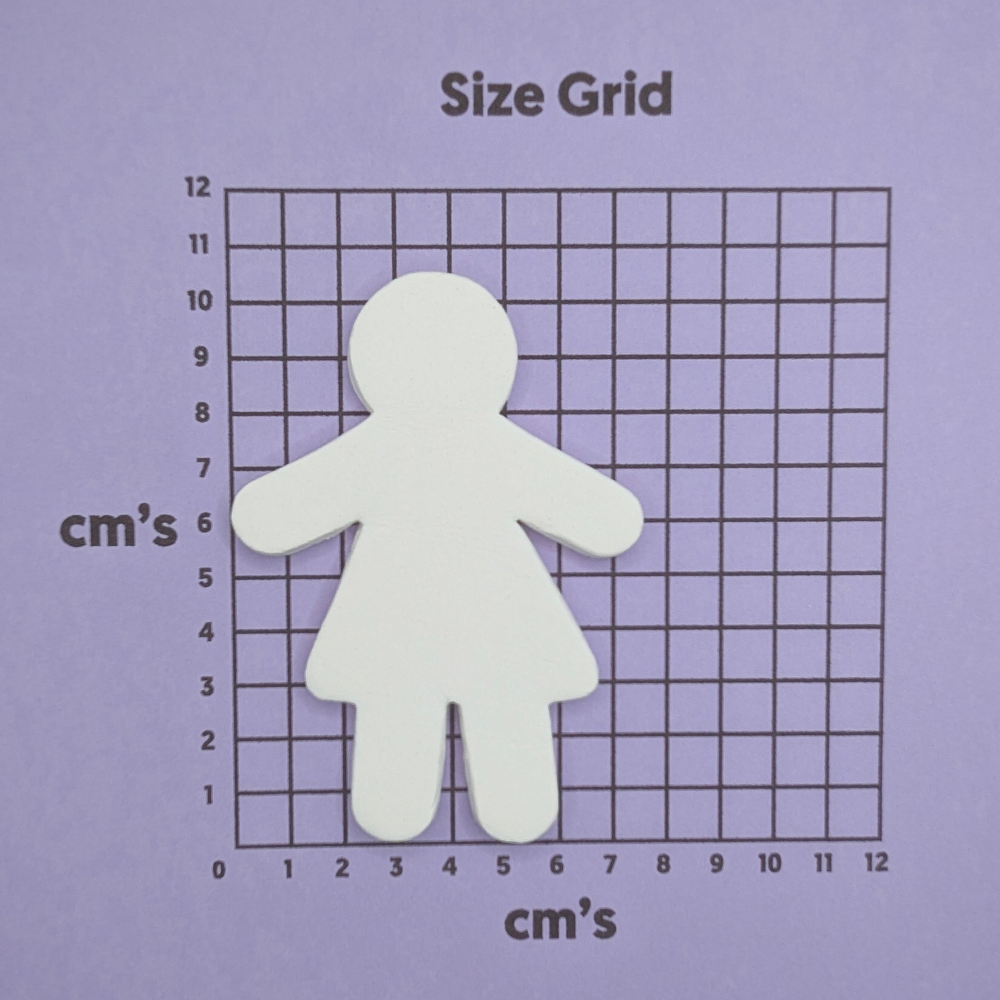 female shaped clay decoration on a size grid with centimeter measurements