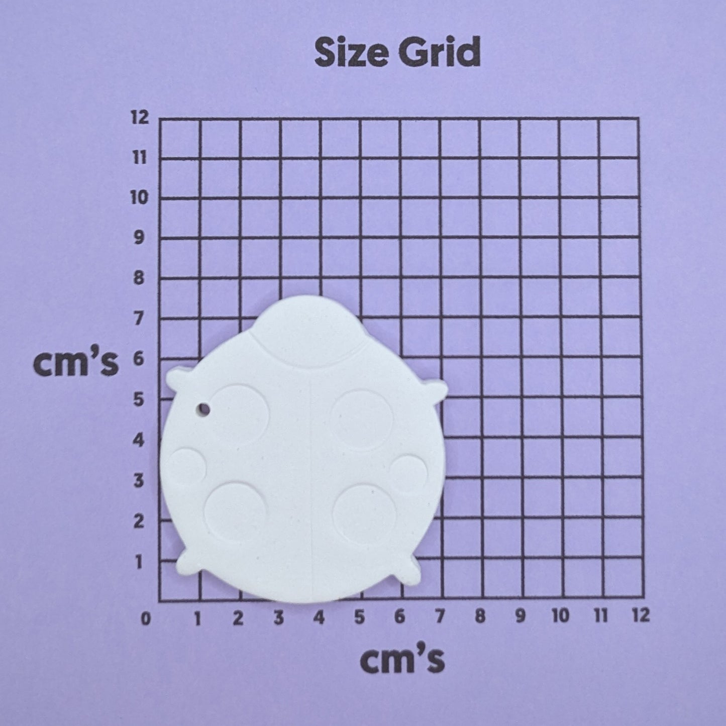 clay ladybug decoration on a size grid with measurements in centimeters 