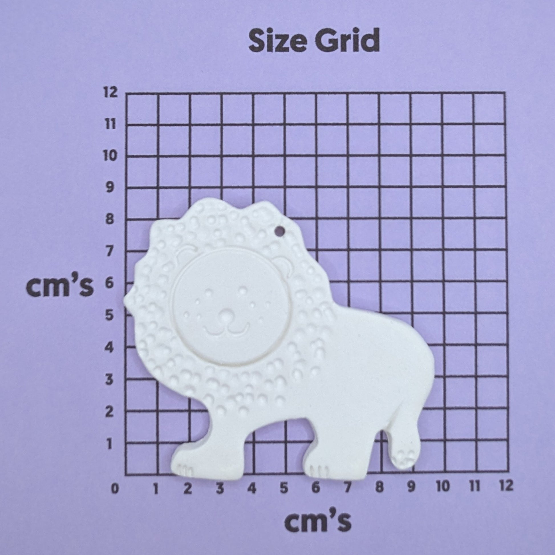 clay lion decoration on a size grid with measurements in centimeters 