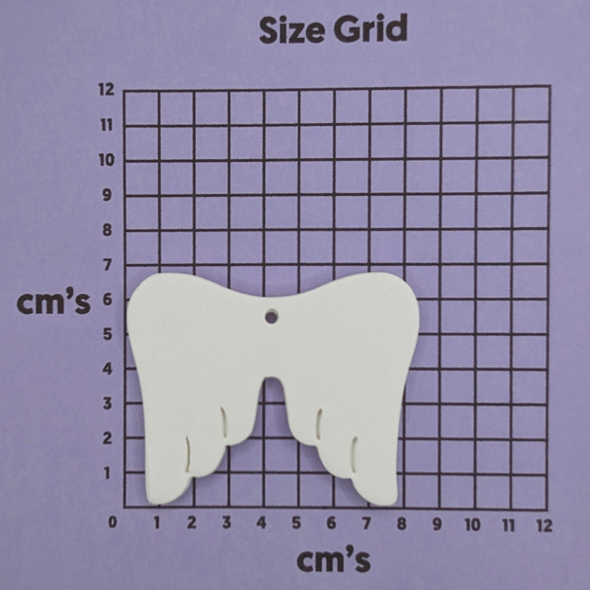 white air dried clay memorial angel wings, shown on cm size grid