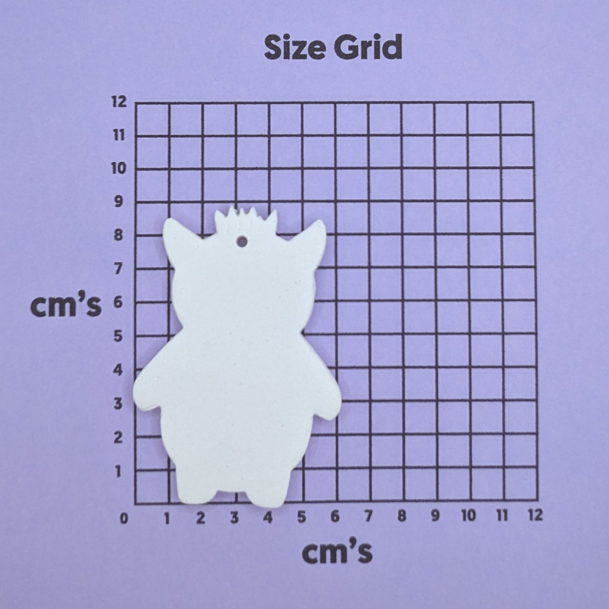 clay monster decoration on a size grid with measurements in centimeters 