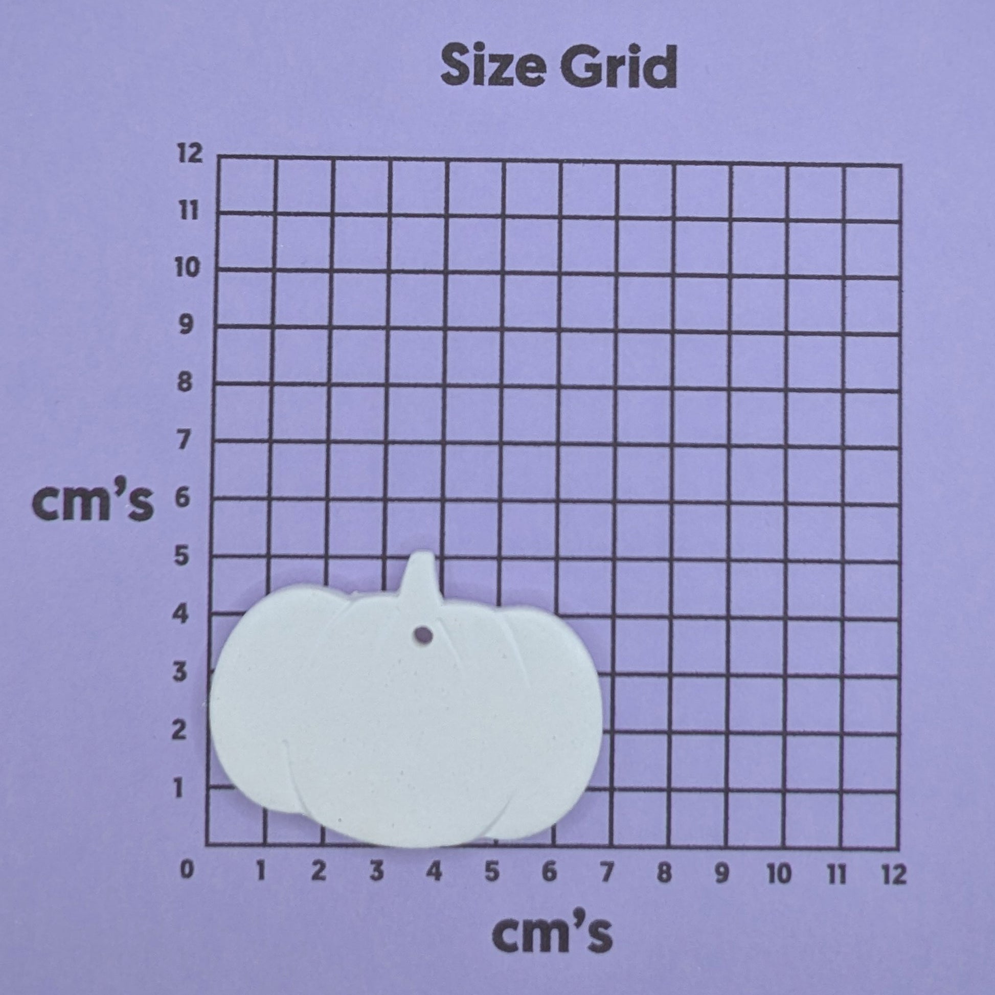 clay pumpkin decoration on a size grid with measurements in centimeters 