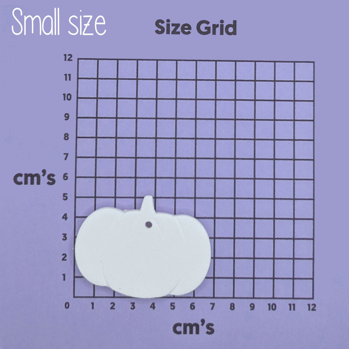 Small pumpkin-shaped clay decoration on a size grid with measurements in centimeters 