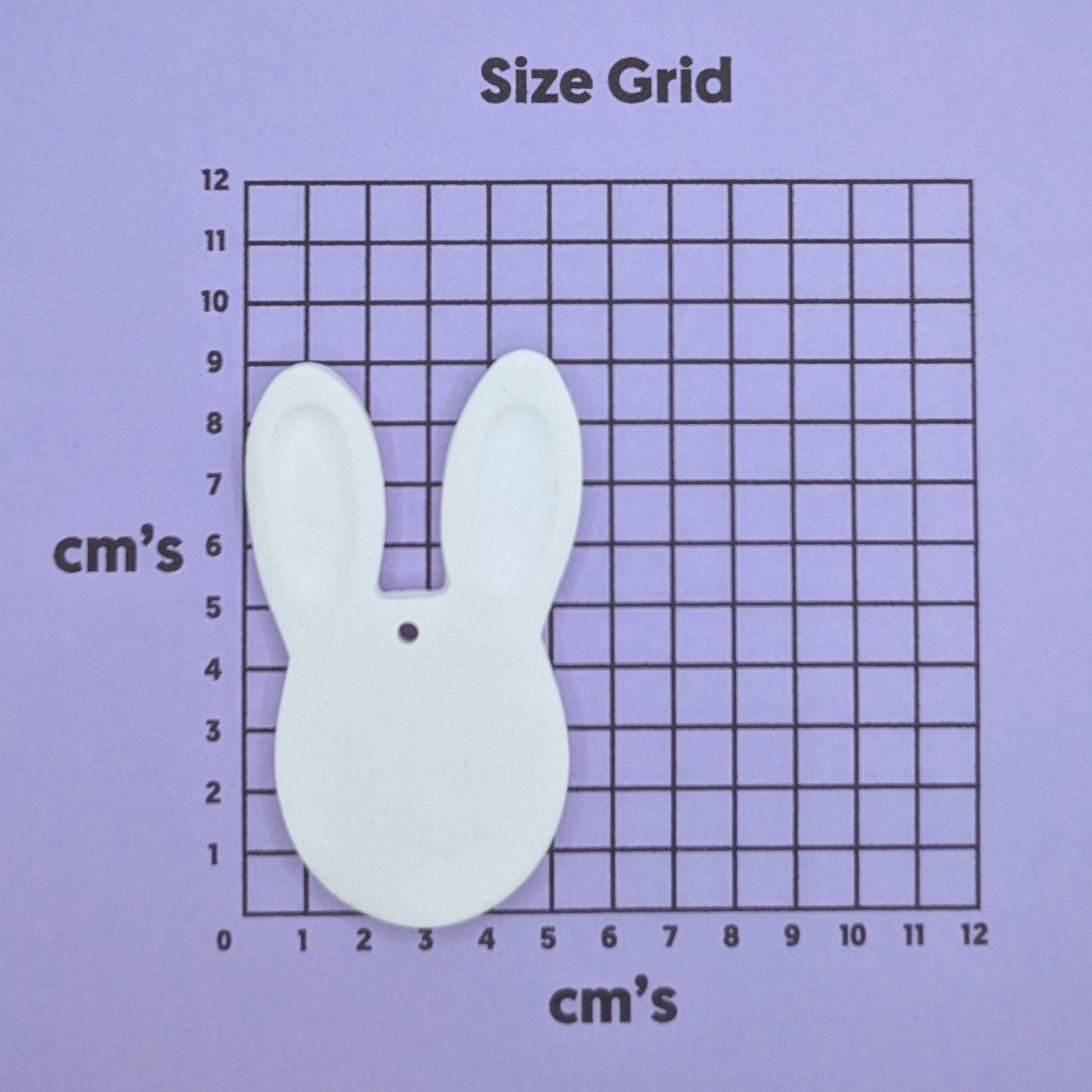 clay rabbit face decoration on a size grid with measurements in centimeters 