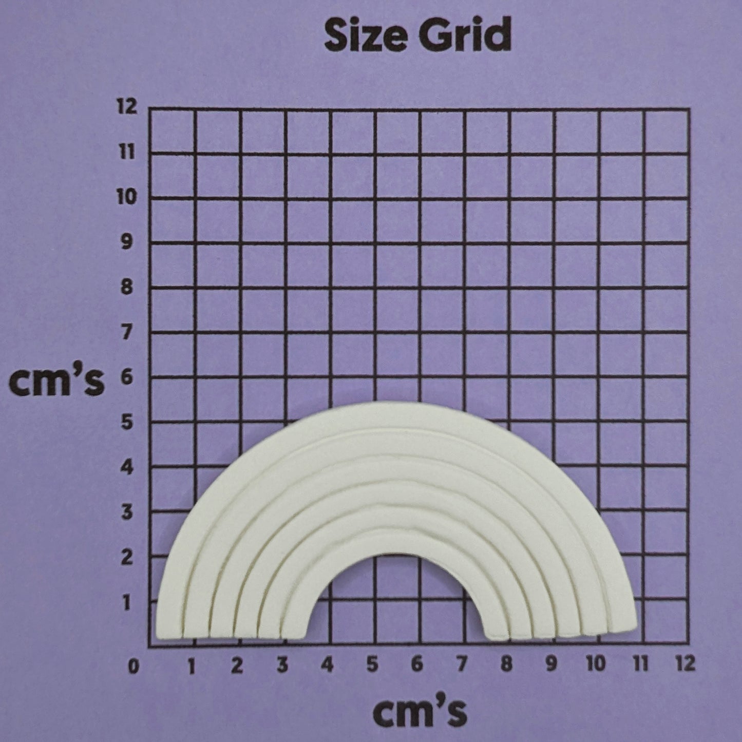 clay rainbow on a purple background with a grid in cm's to show size