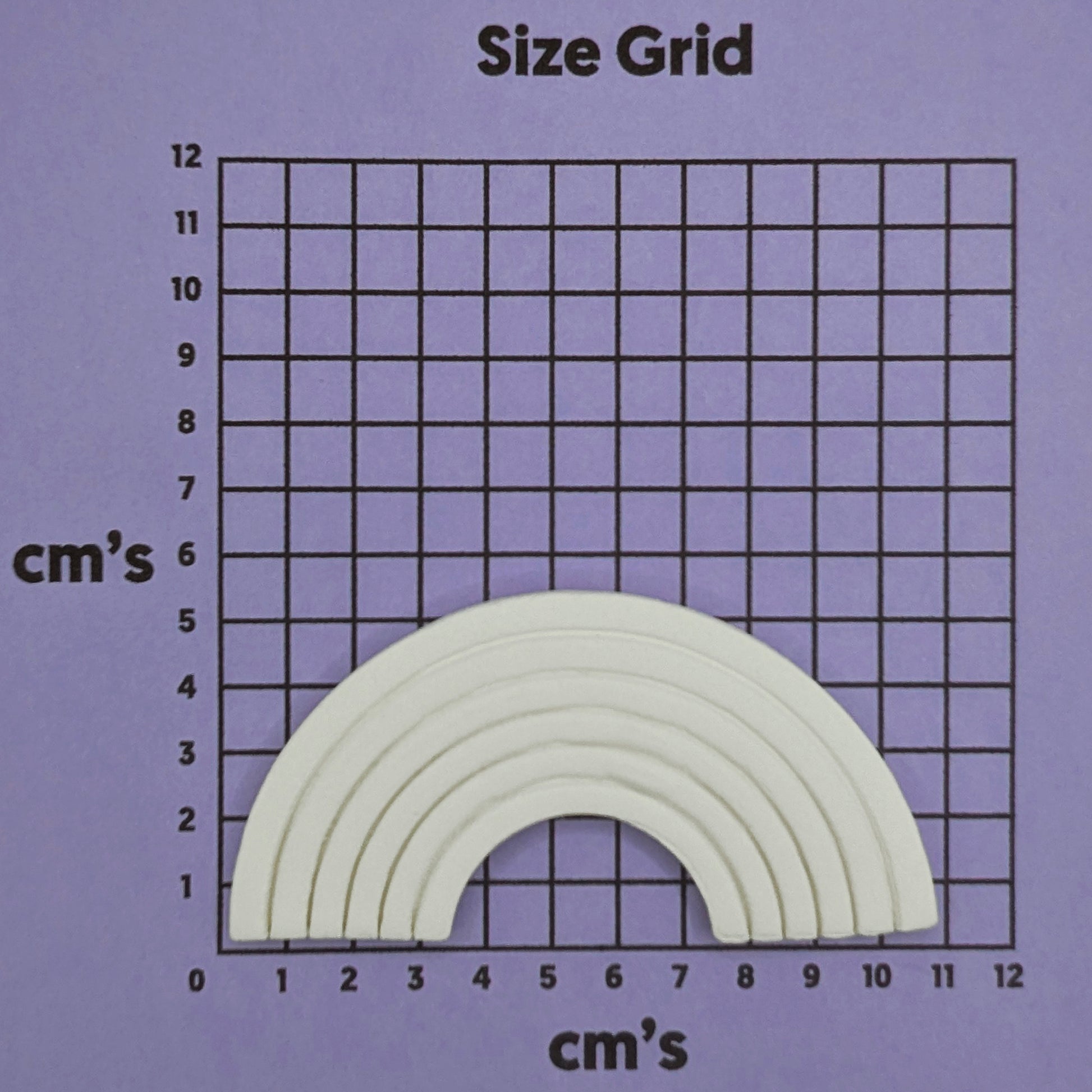 clay rainbow on a purple background with a grid in cm's to show size