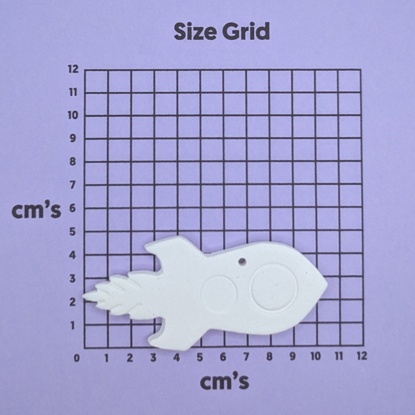clay rocket decoration on a size grid with measurements in centimeters 