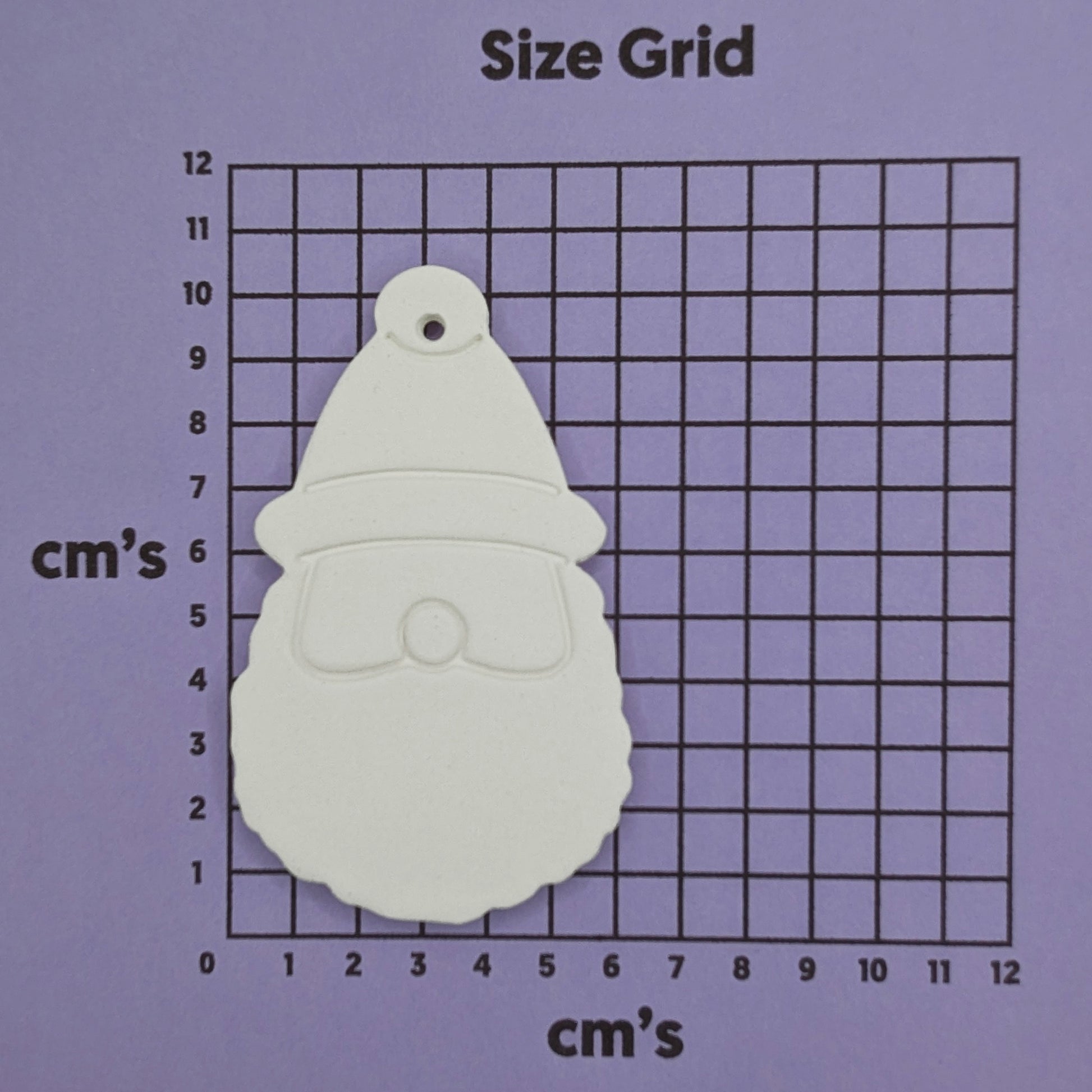 White Santa Claus-shaped clay decoration on a size grid with measurements in centimeters.