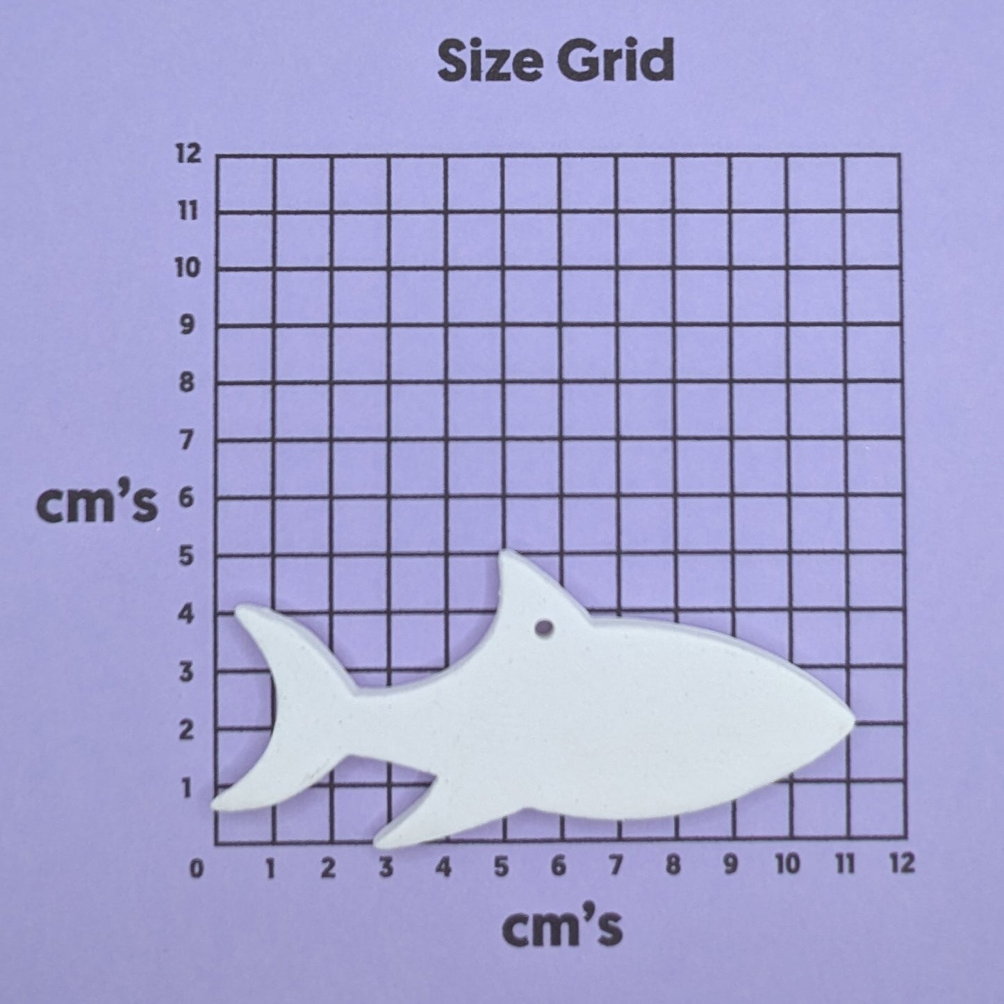 clay shark decoration on a size grid with measurements in centimeters 