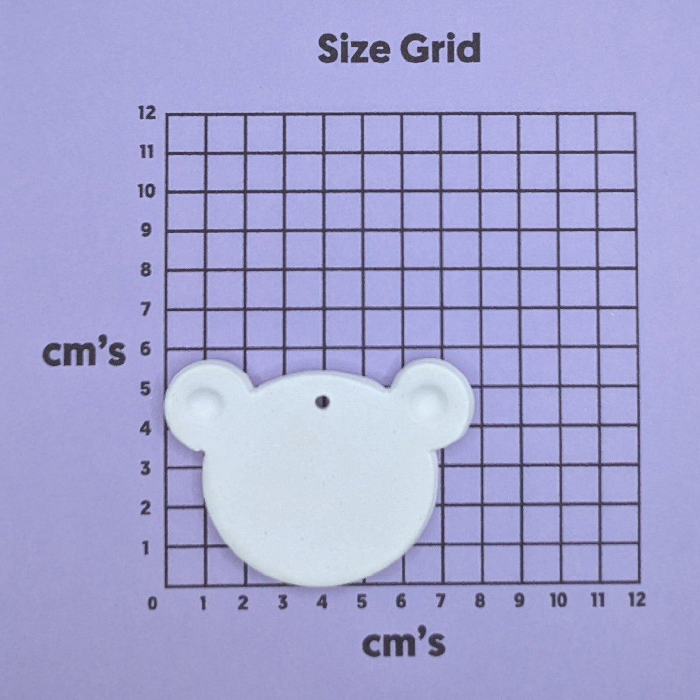 clay teddy bear face / head decoration on a size grid with measurements in centimeters 