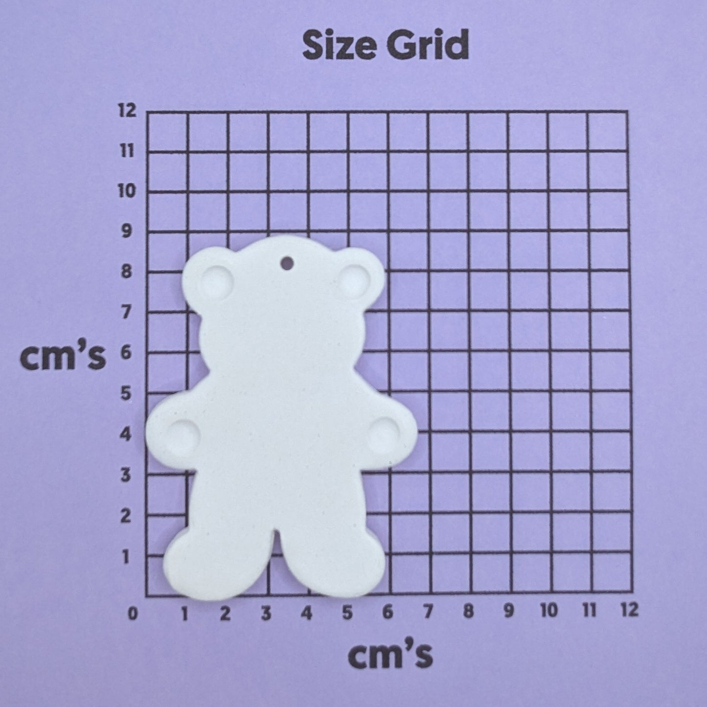 clay teddy bear decoration on a size grid with measurements in centimeters 
