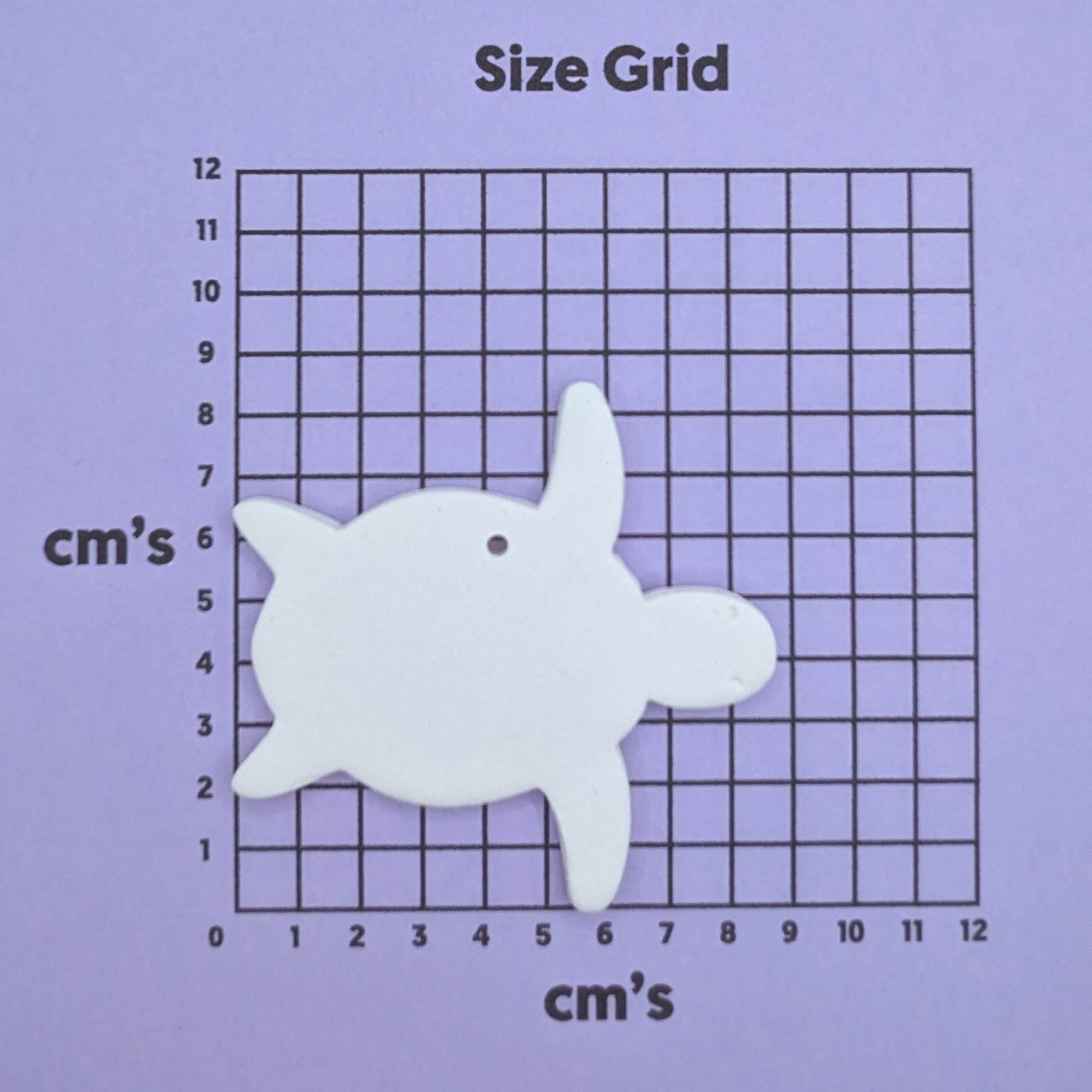 clay turtle decoration on a size grid with measurements in centimeters 
