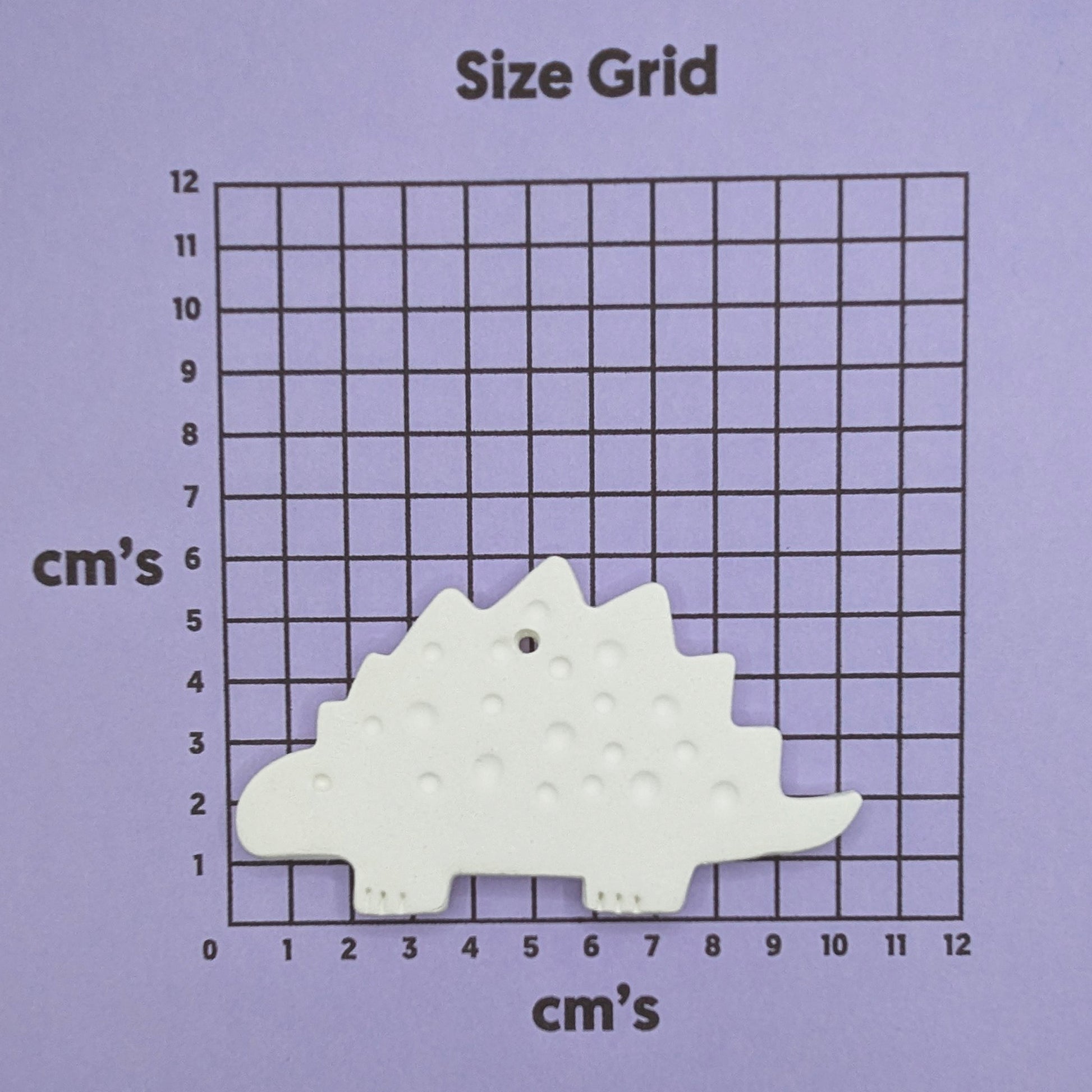 clay dinosaur decoration on a size grid with measurements in centimeters 