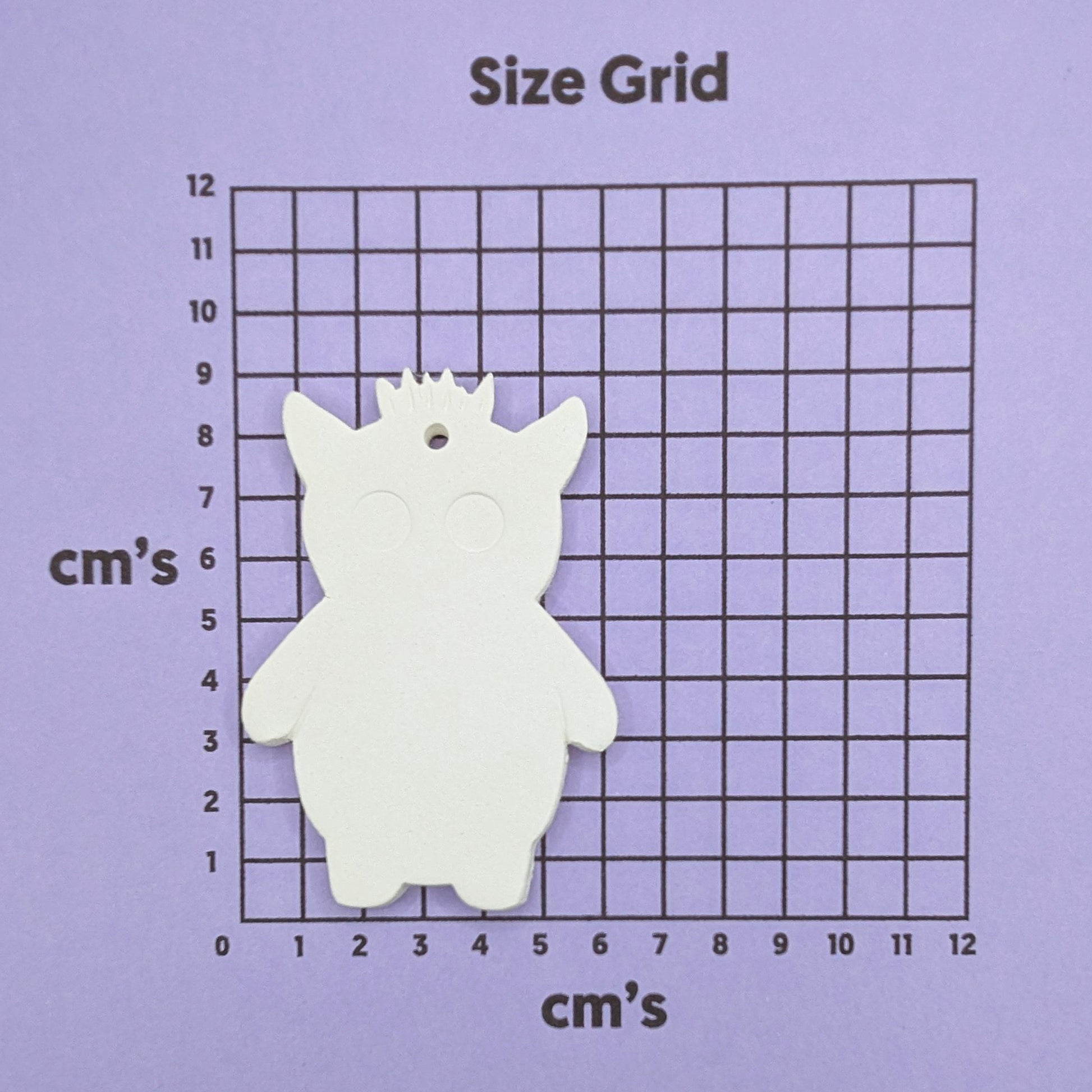 clay monster decoration on a size grid with measurements in centimeters 
