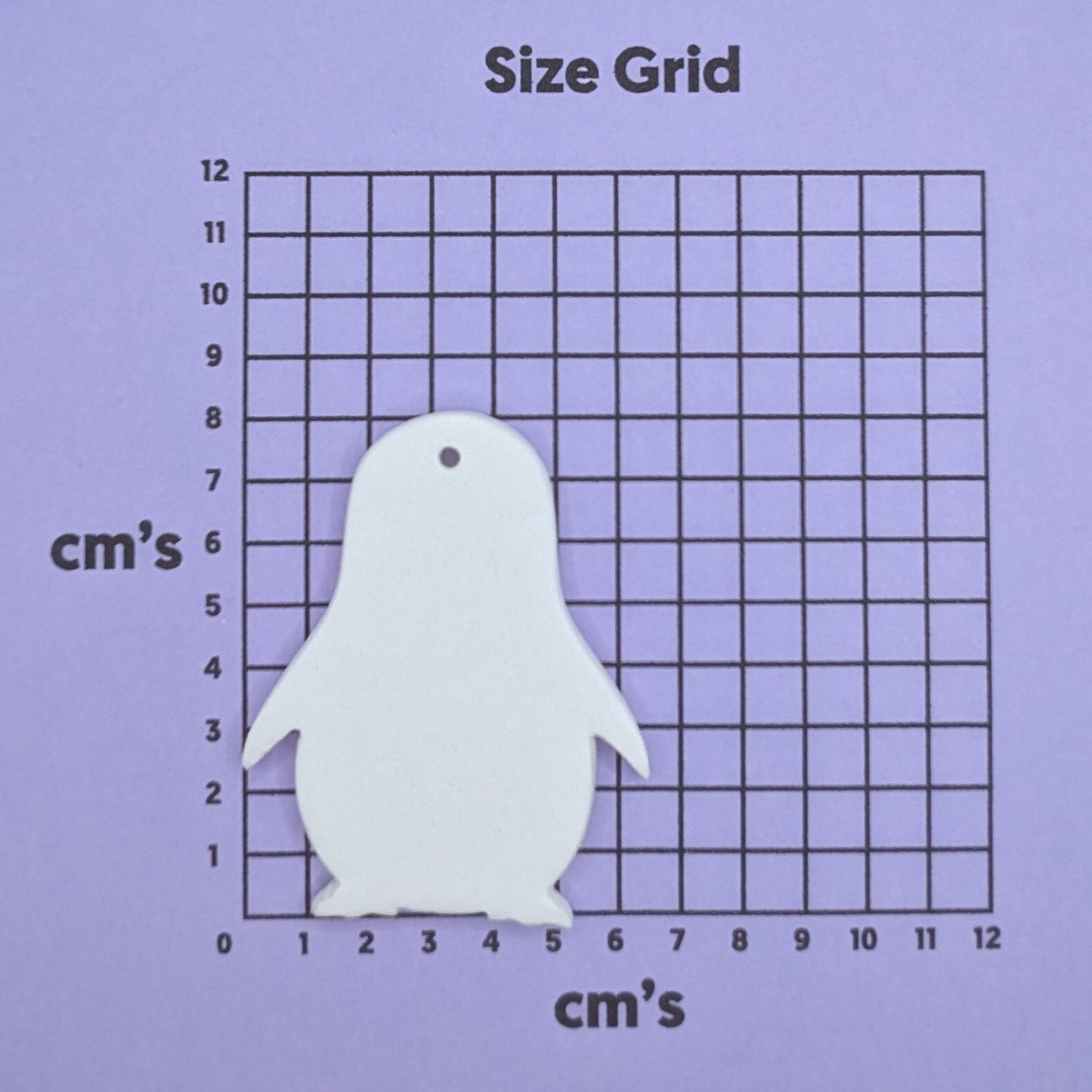clay penguin decoration on a size grid with measurements in centimeters 