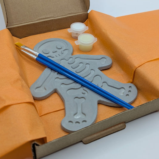 close up of skeleton clay kit, with glow in the dark paint and brushes