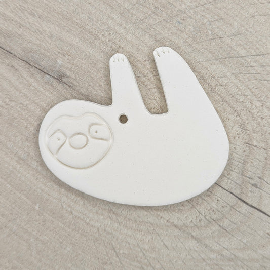 Sloth clay decoration on a ligh wood background