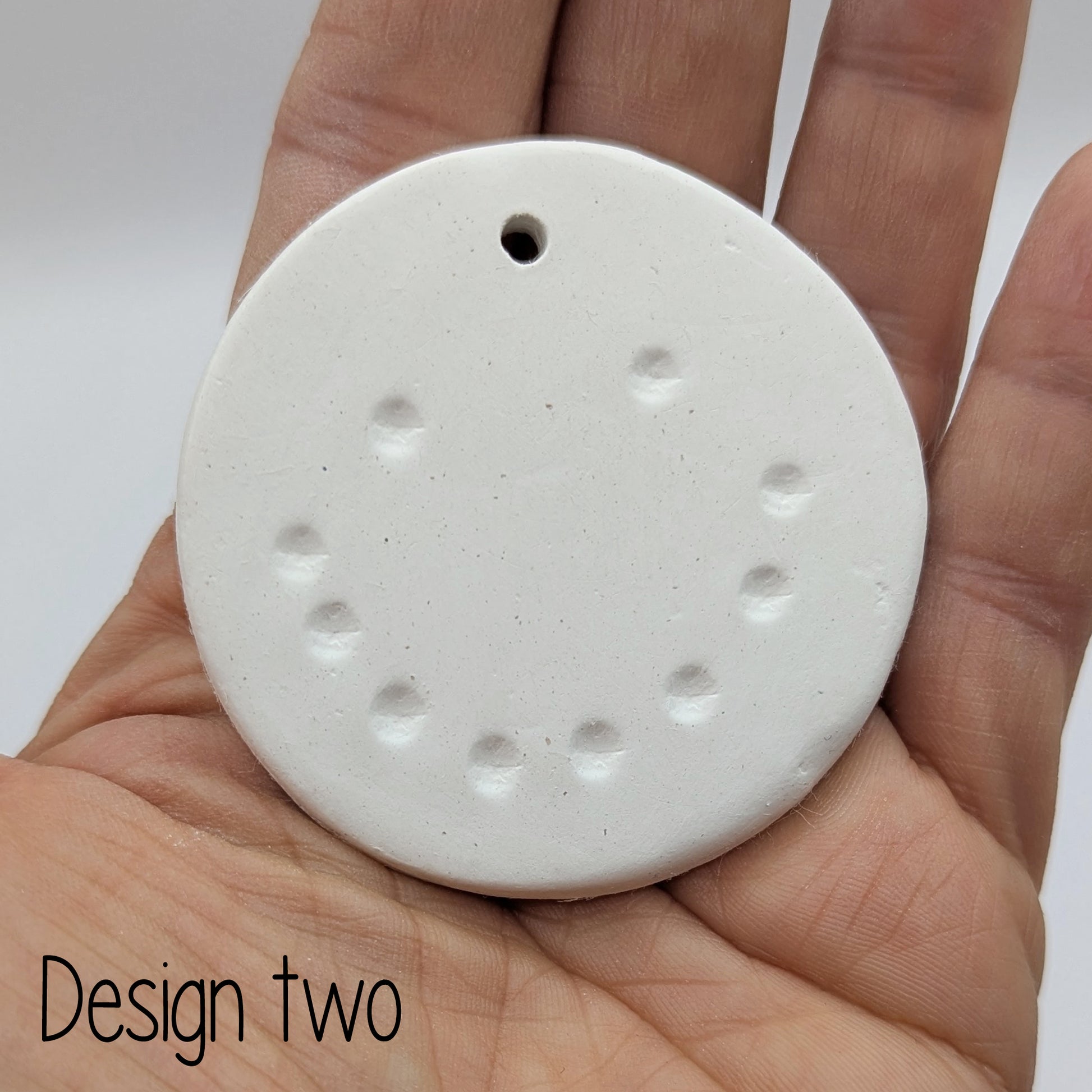 snowman face - design 2, made of air dried clay, shown in palm of hand