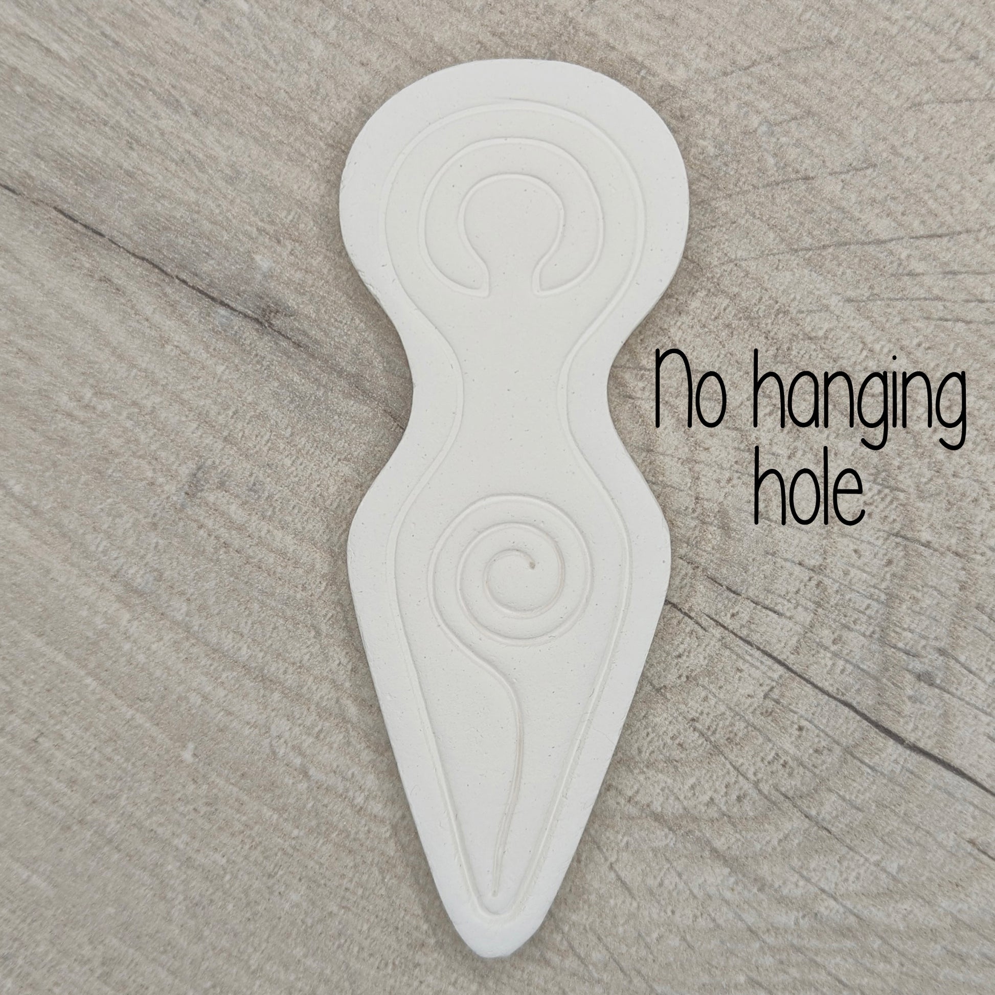 Spiral goddess shaped clay decoration shown on a light wood background, with wording no hanging hole