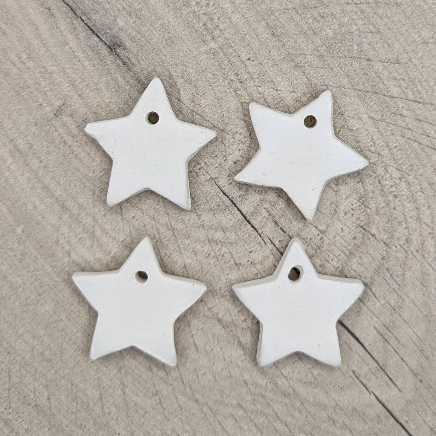 sample of tiny clay stars - 4 shown on wooden background