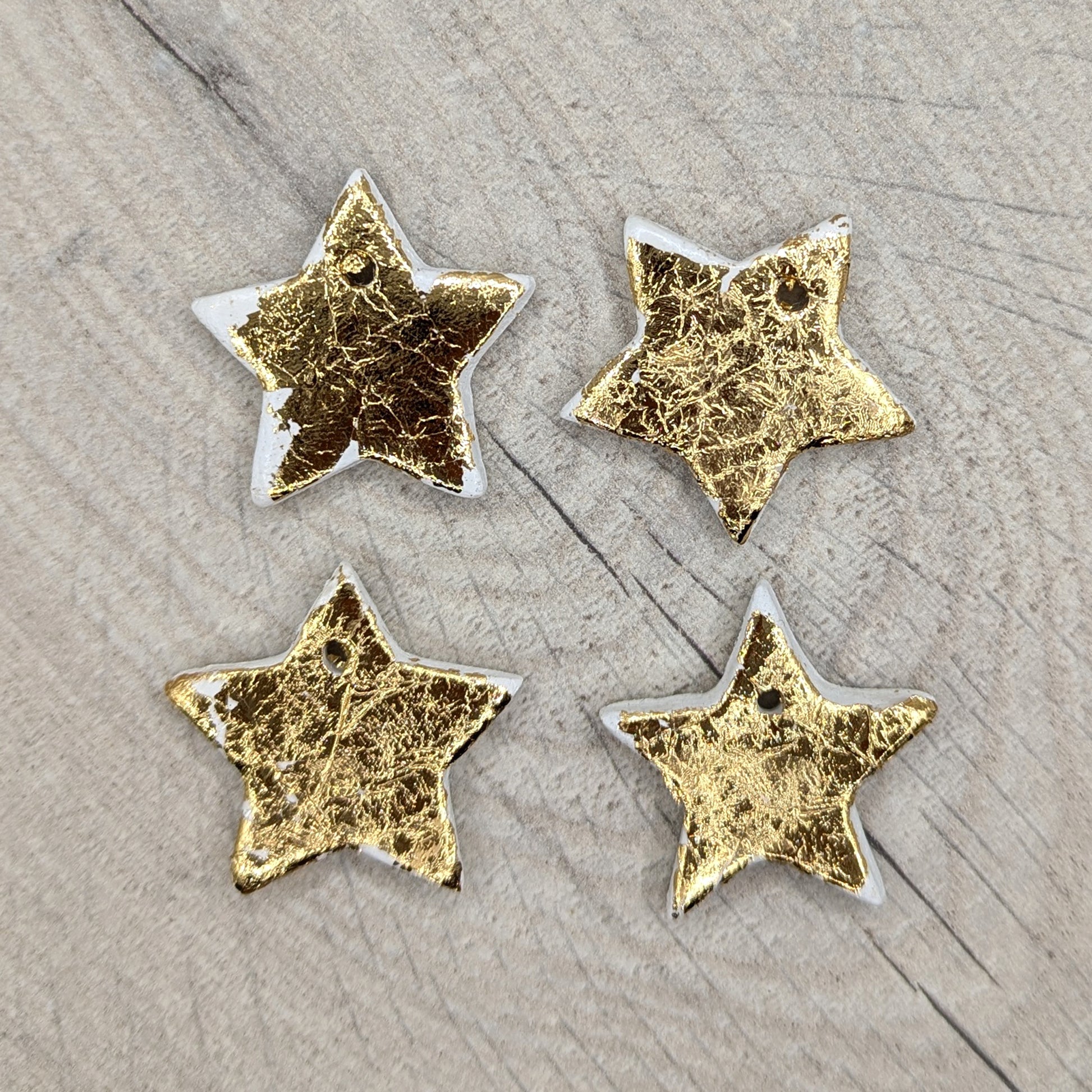 sample of tiny gold stars, 4 shown on wooden background