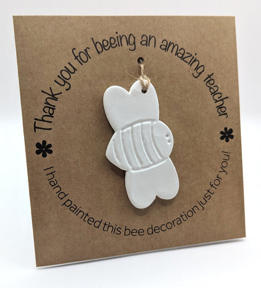'Thank you for beeing an amazing teacher' text on a brown kraft card with  a clay bee decoration attached for you to paint and decorate