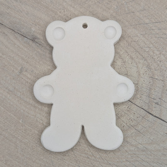 White clay decoration in the shape of a teddy bear with ears  and paws stamped on