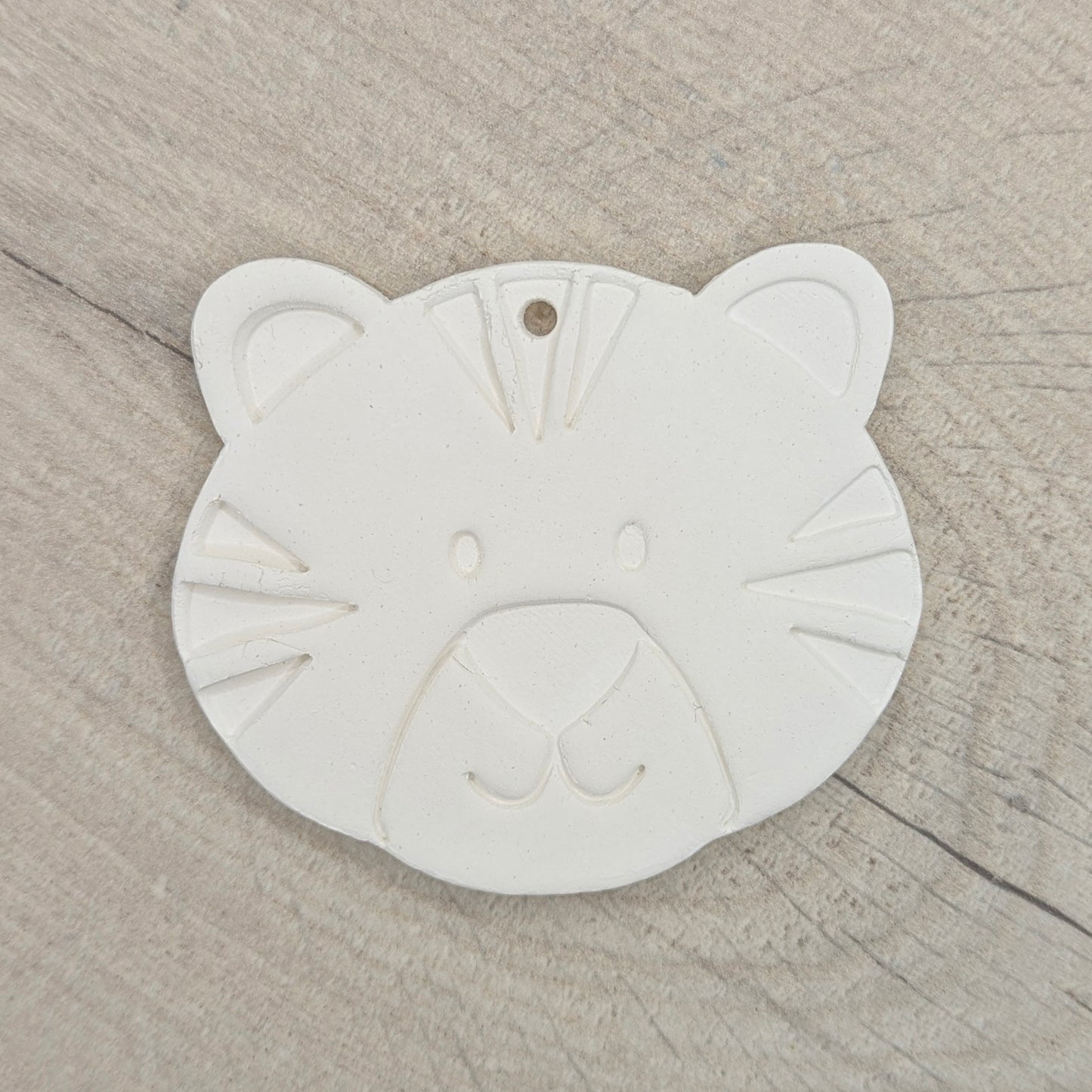 clay decoration in the shape of a tiger cub on a wooden background