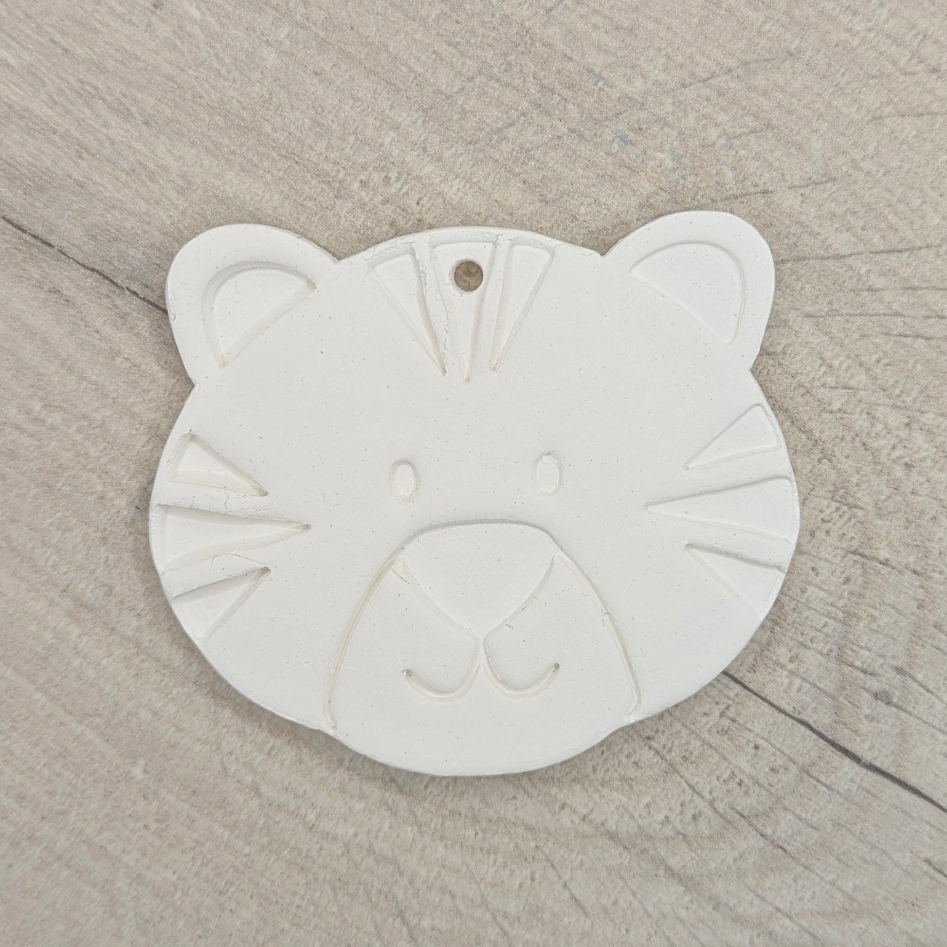 clay decoration in the shape of a tiger cub on a wooden background