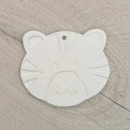 clay decoration in the shape of a tiger cub on a wooden background