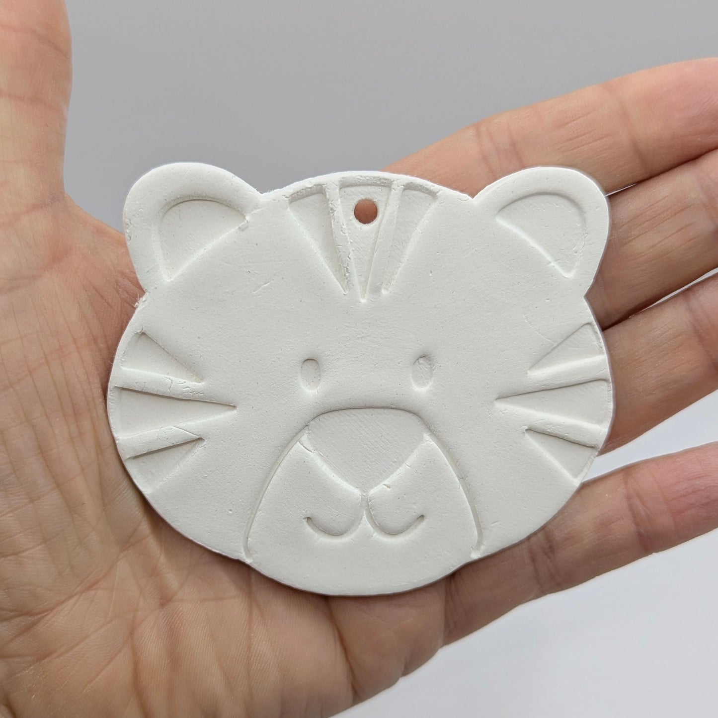 Tiger cub clay decoration shown in a hand to show size