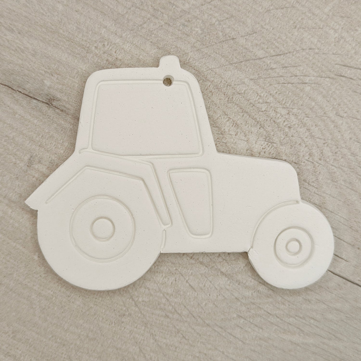 White clay tractor on a wooden surface