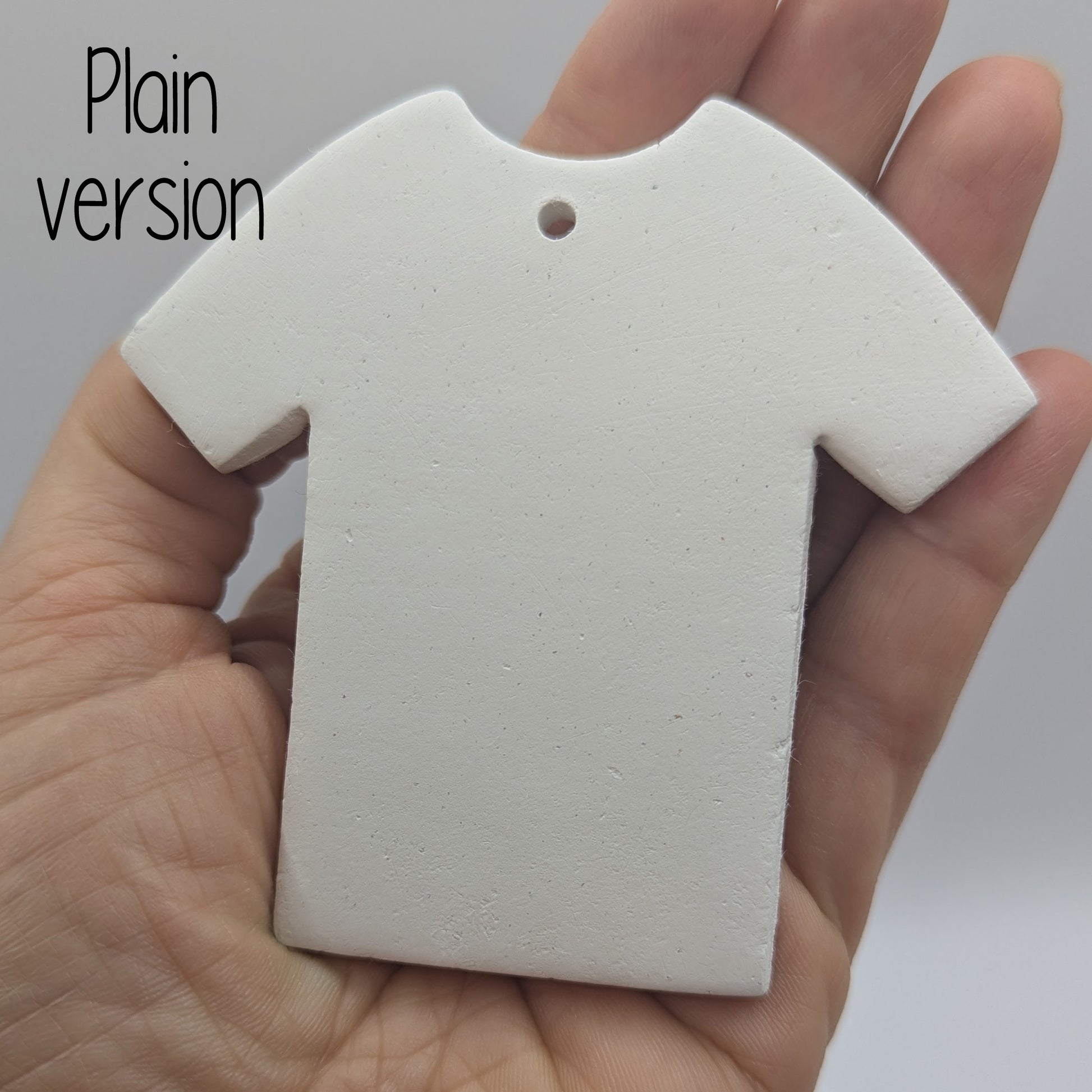plain t-shirt clay decoration being held in a hand to show size