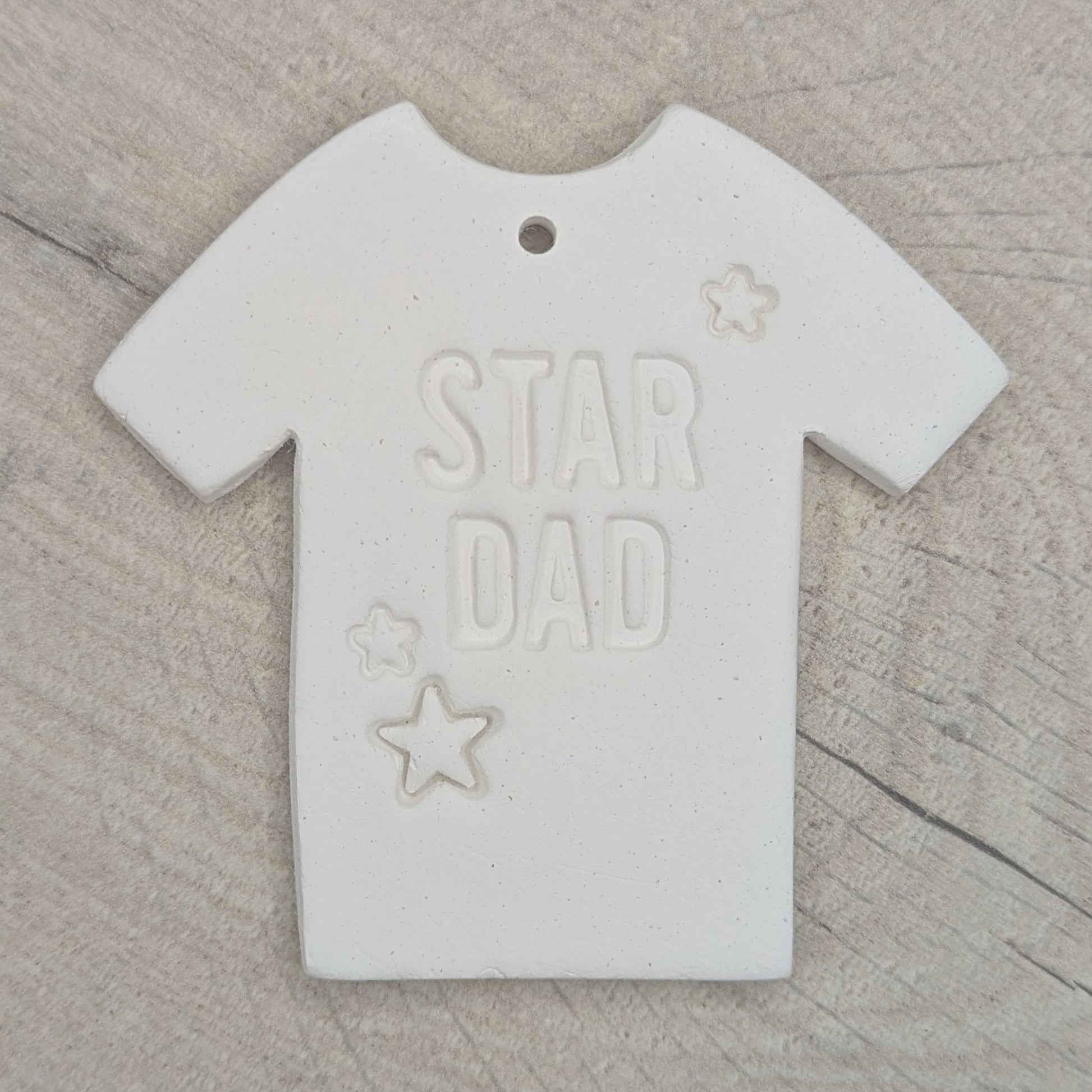 White clay t-shirt-shaped ornament / decoration with 'Star Dad' and small stars stamped into the clay