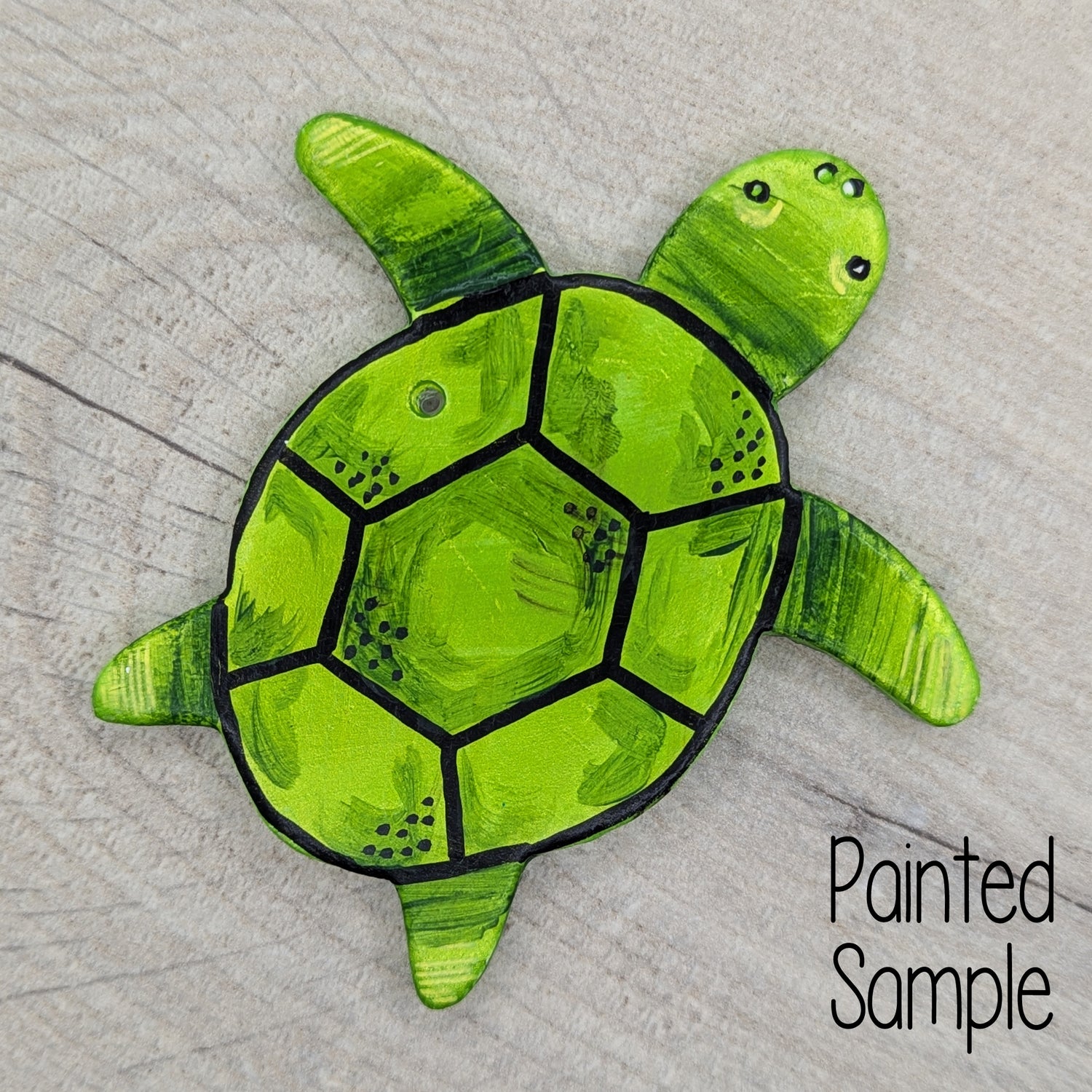 sample of a turtle decoration, painted in green acrylic paint with black sharpie shell outlines