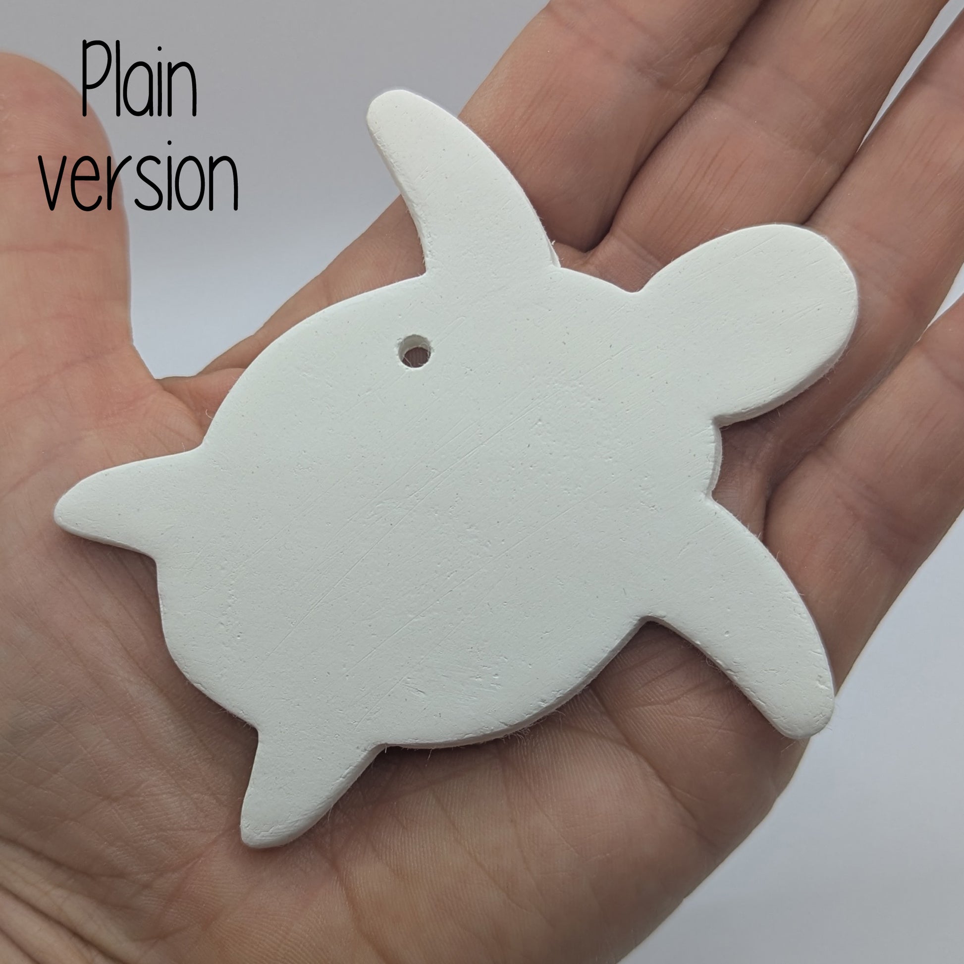 clay shaped turtle decoration in some ones hand to show scale
