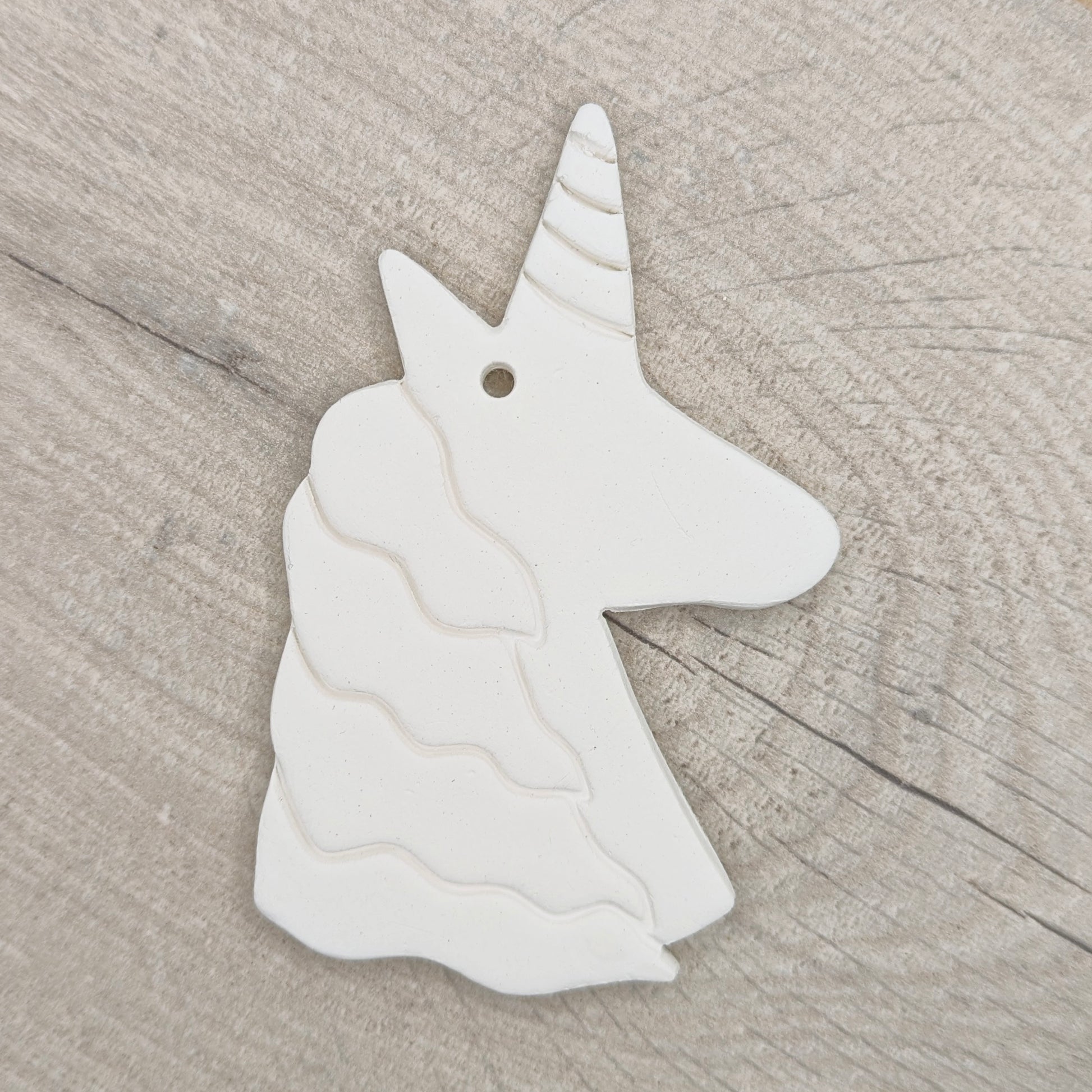 unicorn clay decoration on light wood background