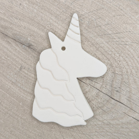 unicorn clay decoration on light wood background