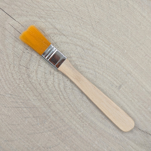 Paintbrush with yellow bristles and a wooden handle