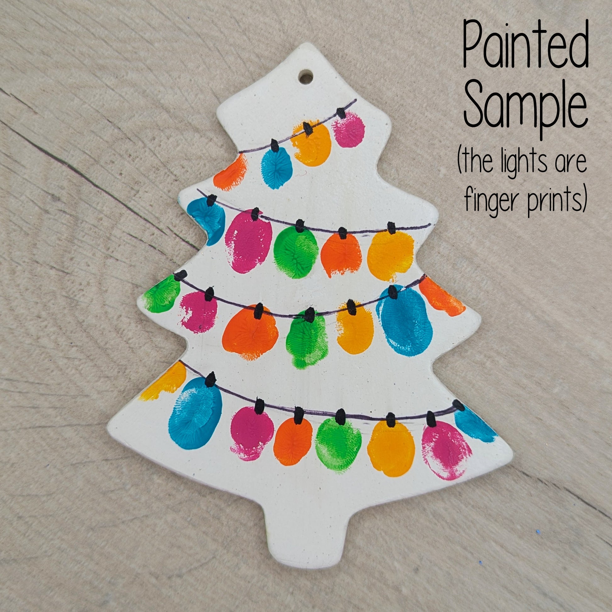 sample of painted Christmas tree decoration, made of white air dried clay and then painted using finger prints to look like fairy lights with a black pen line connecting them