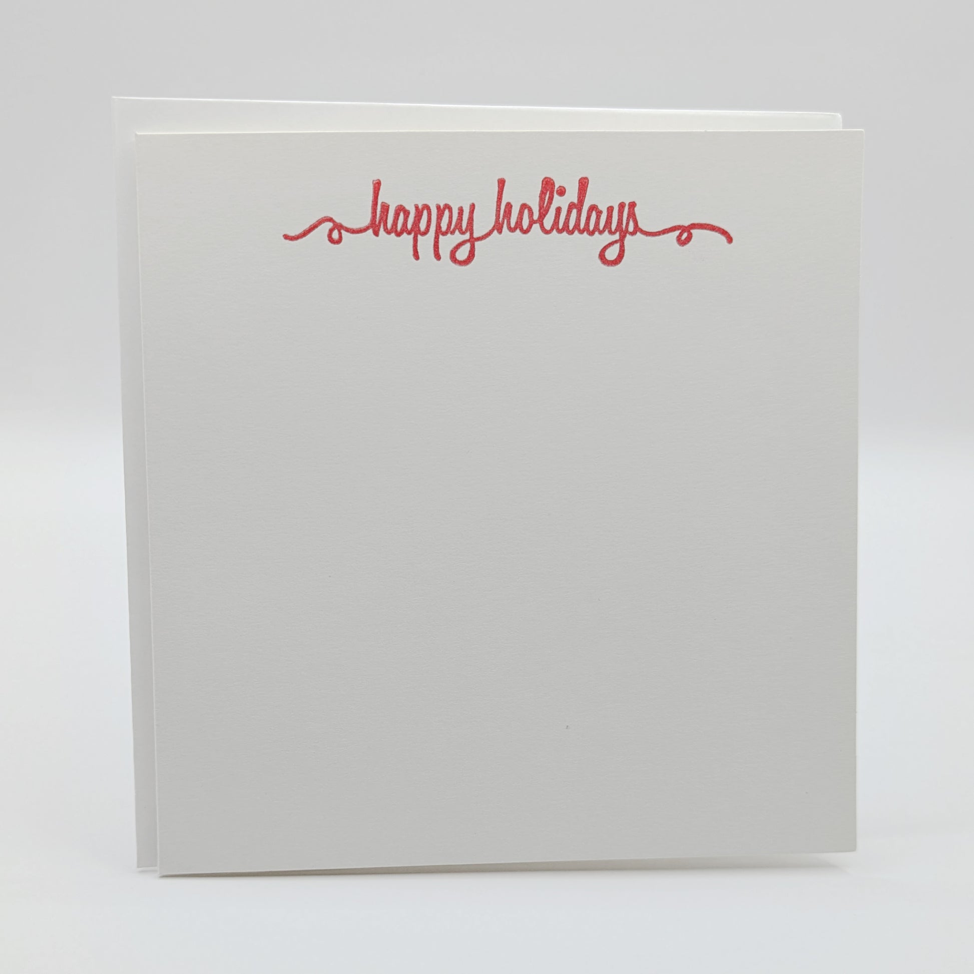 happy holidays stamped in red ink onto a white card, comes with matching envelope